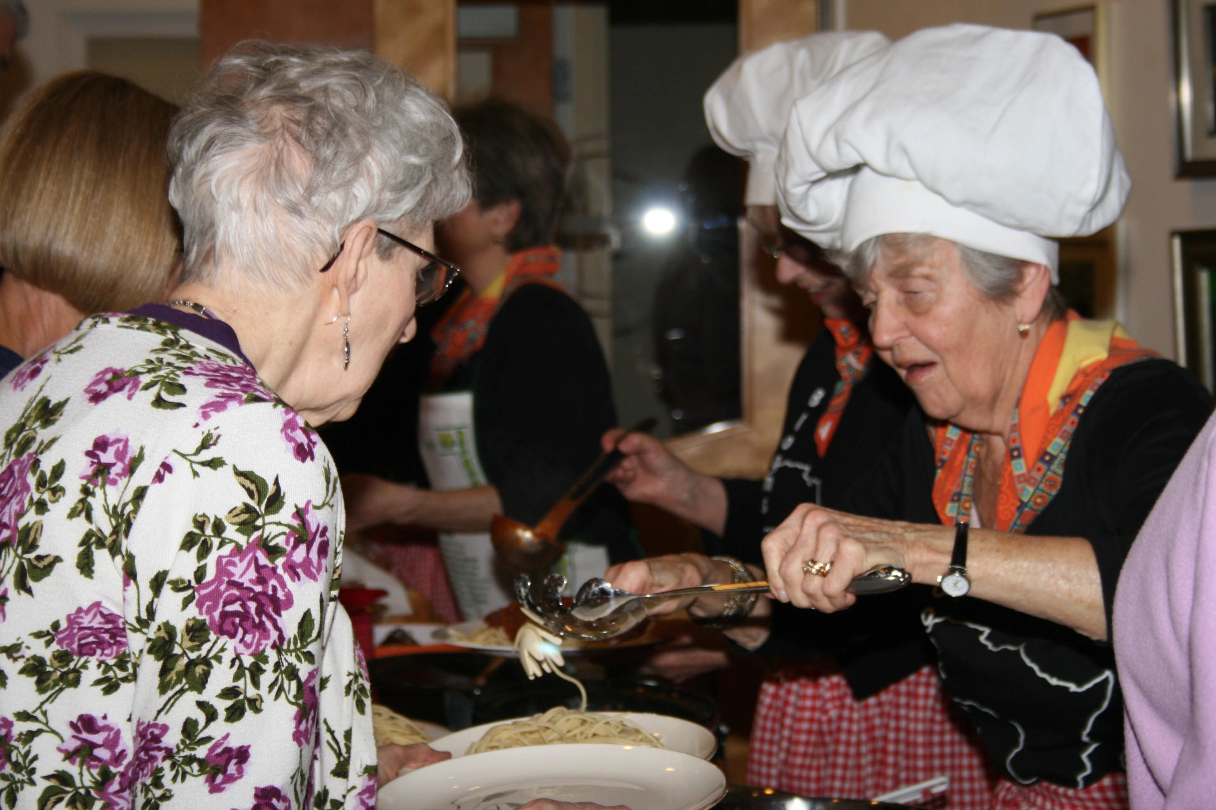 grandmothers serving pasta